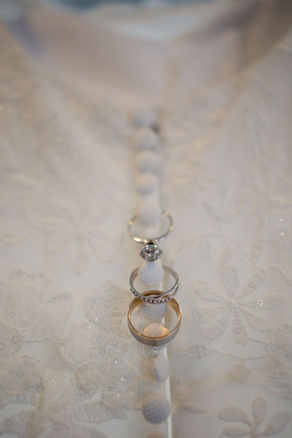 Close-up sequence of a sparkling diamond engagement ring on a textured lace background.
