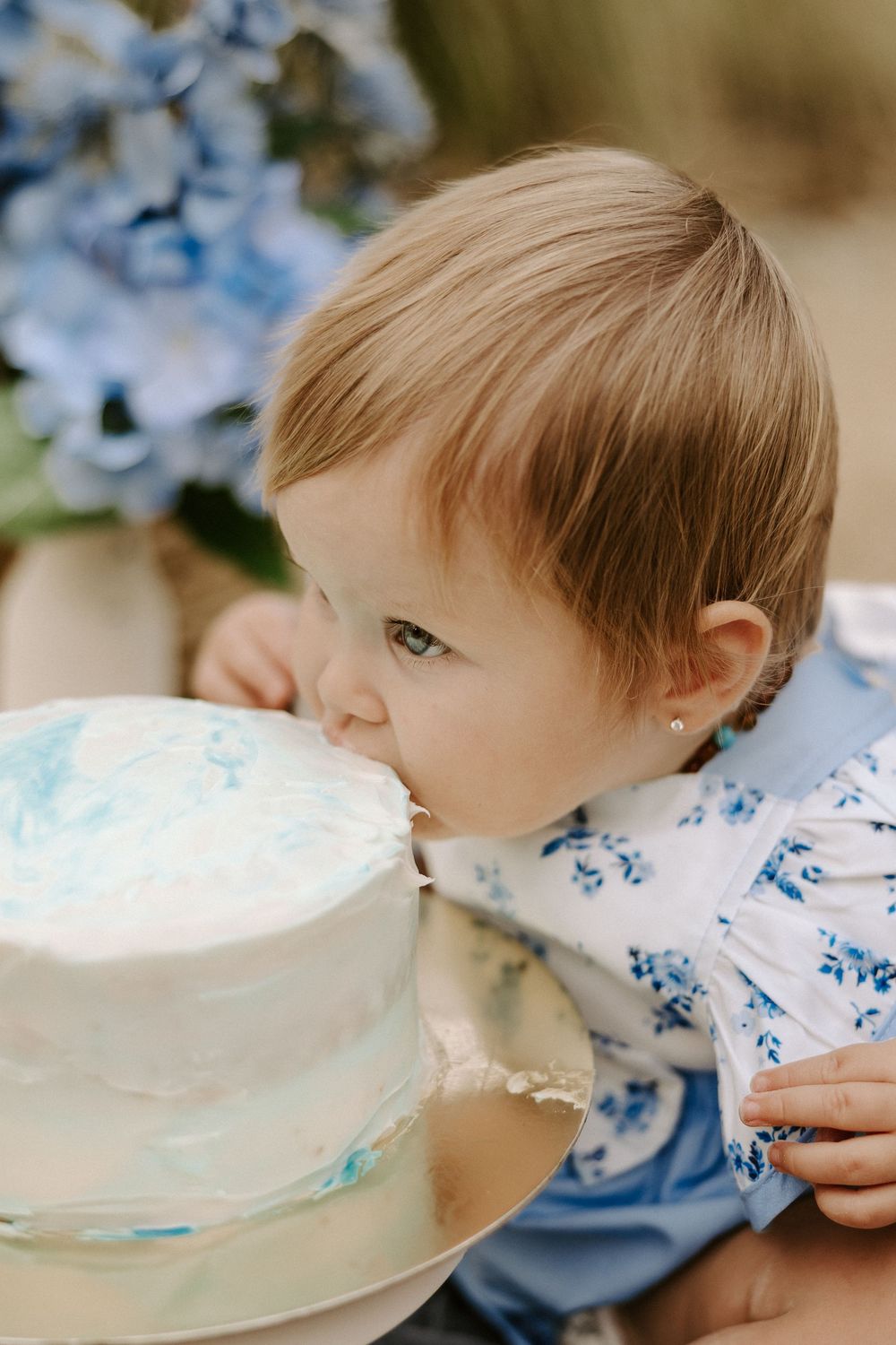 Sequence of close-up shots showing someone blowing bubbles with a white plate and blue floral decorations.