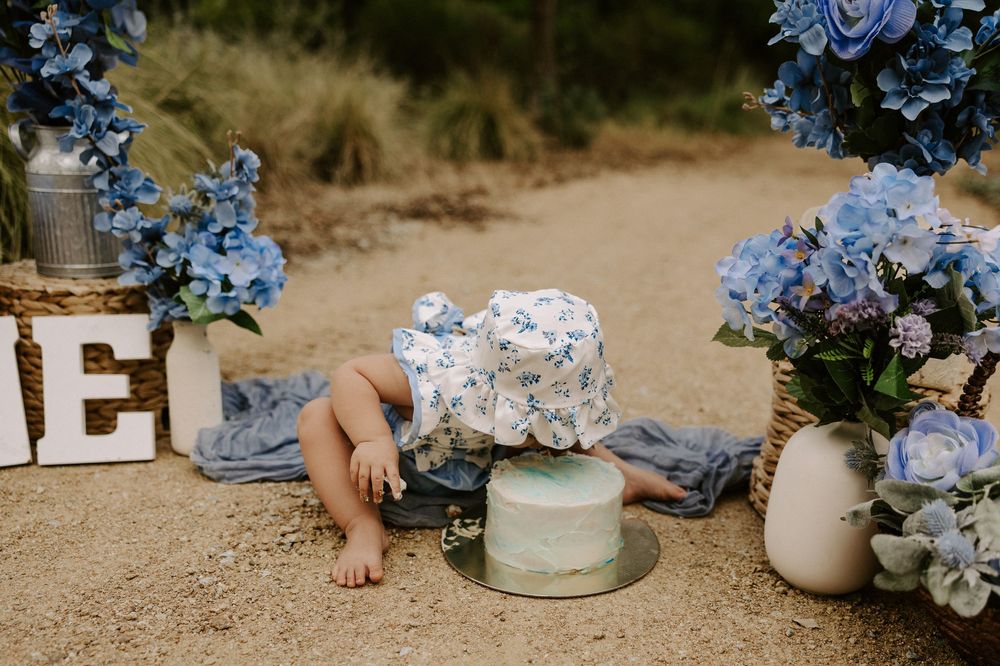 Delicate blue and white hydrangea flowers arranged in ceramic vases on a rustic outdoor surface.
