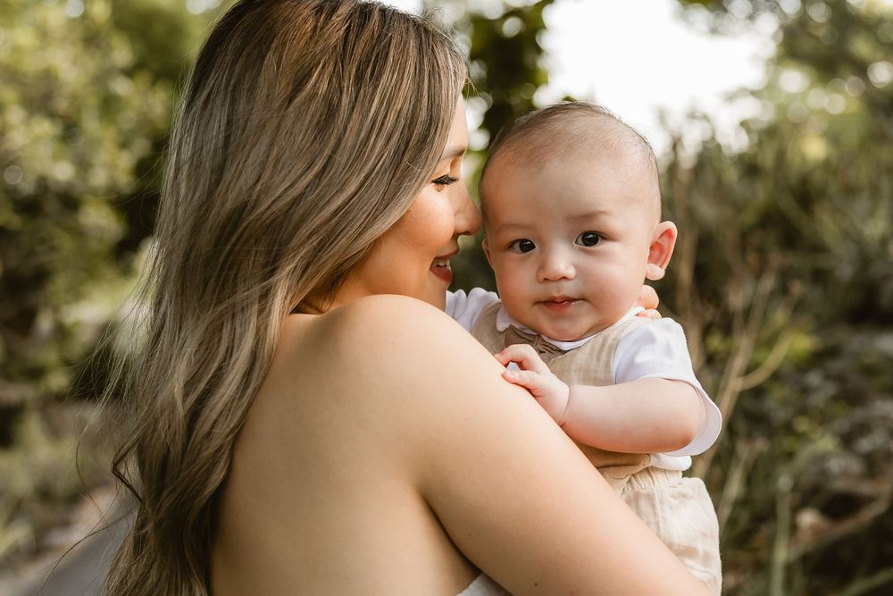 Mum holding baby close while he looks at the camera during a natural family photo session in Brisbane’s Mt Coot-tha Botanic Gardens