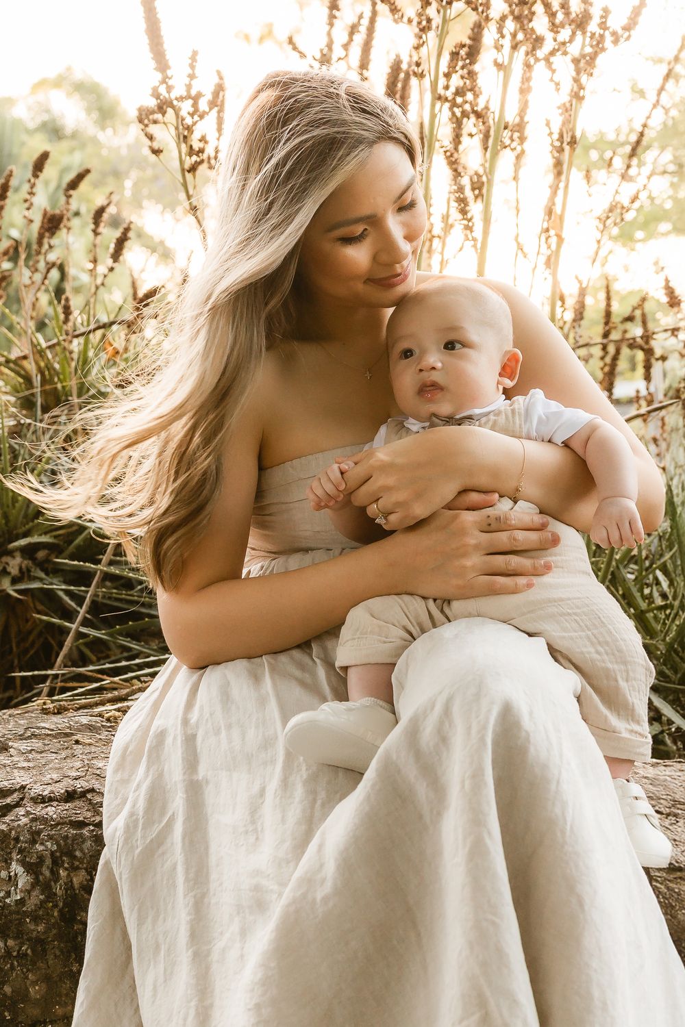 Mother holding baby boy in soft golden light during a natural family session at Mount Coot-tha in Brisbane by Joanna Kate Photography.