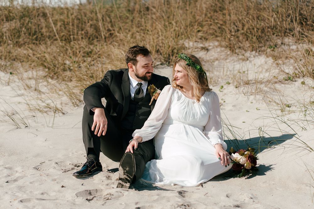 Romantic beach wedding scene with couple lounging on sandy shore in Wedding portrait photography. Carolina Beach, NC