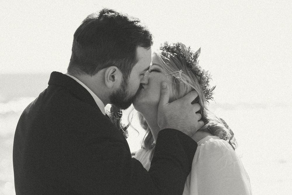 A series of intimate black and white wedding photos showing tender moments between couples.