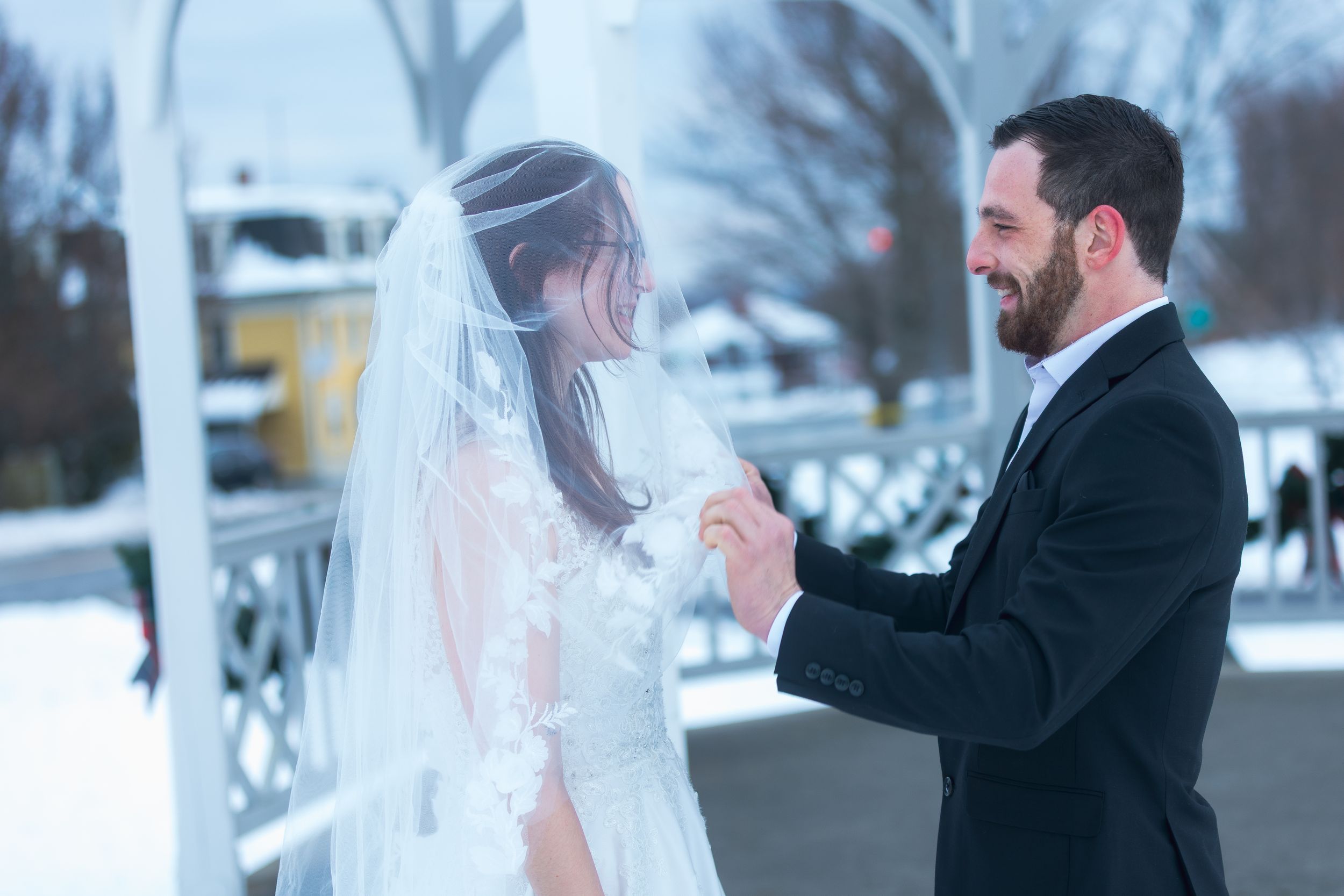Winter wedding photos showing a couple sharing intimate moments in a snowy outdoor setting.