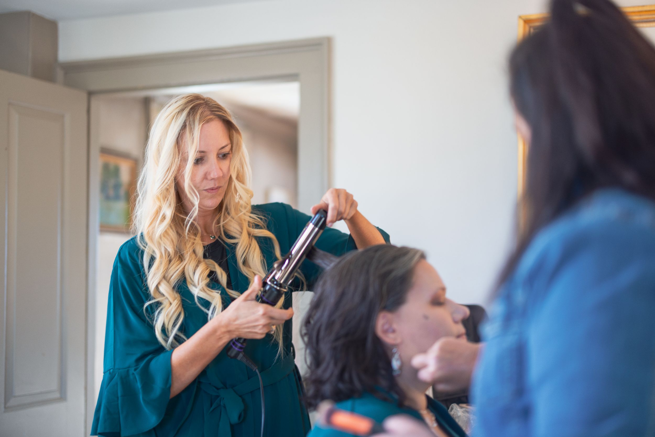 Professional makeup artist applies cosmetics to client in bright studio setting.