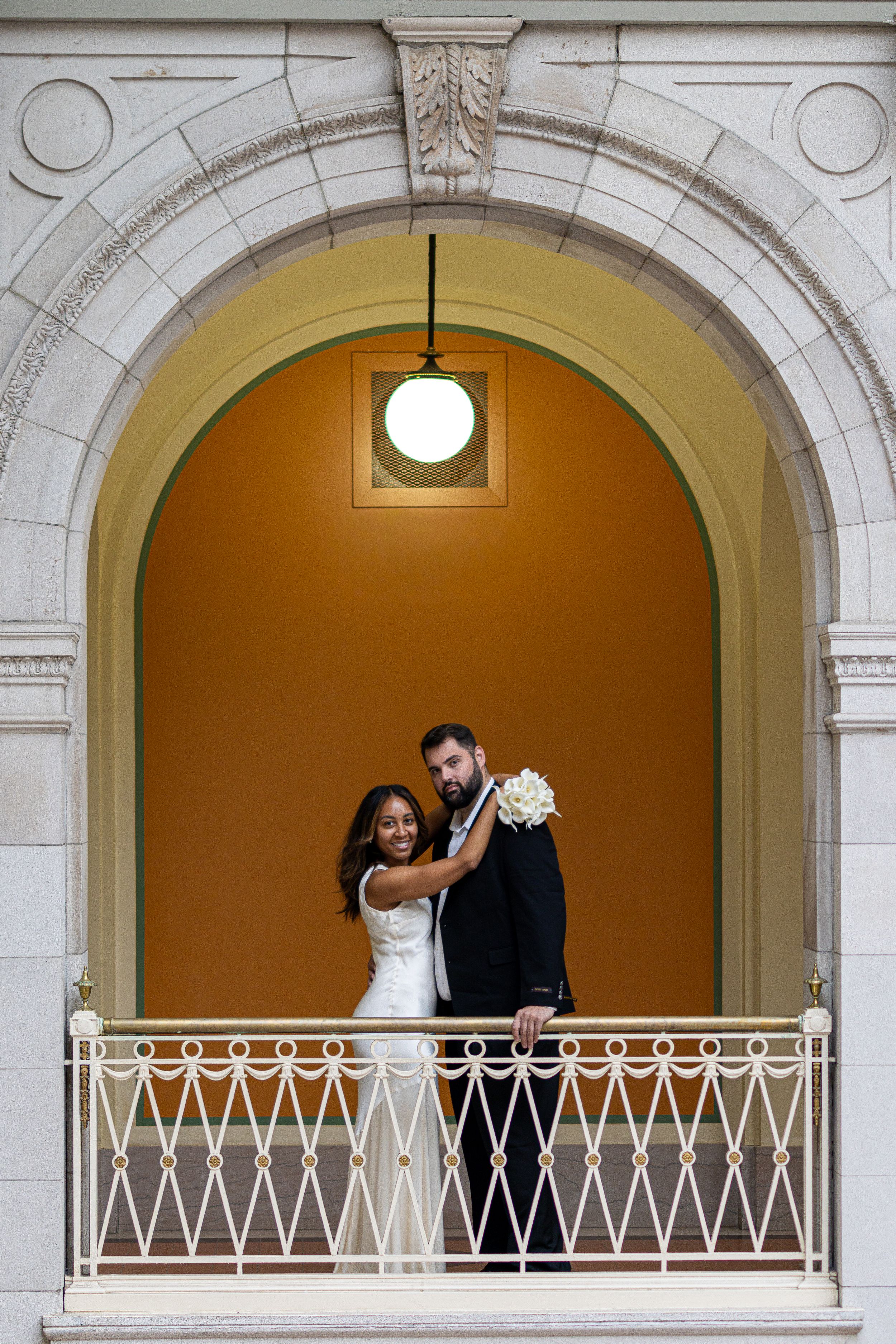 Three arched windows show a romantic wedding scene with a couple embracing in formal attire against a golden backdrop.