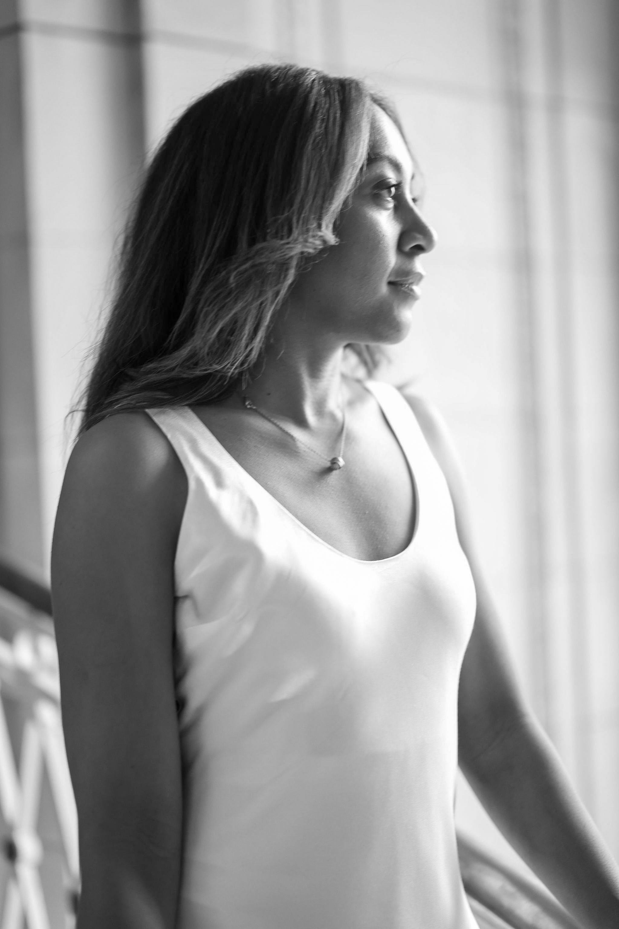 A sequence of black and white profile photos showing a person in a white sleeveless top against a light background.