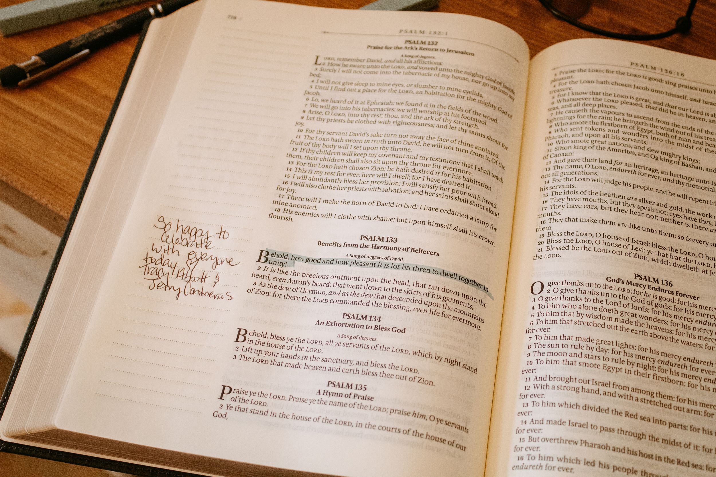 Open Bible with handwritten notes in margins, showing Psalms pages on a wooden table.