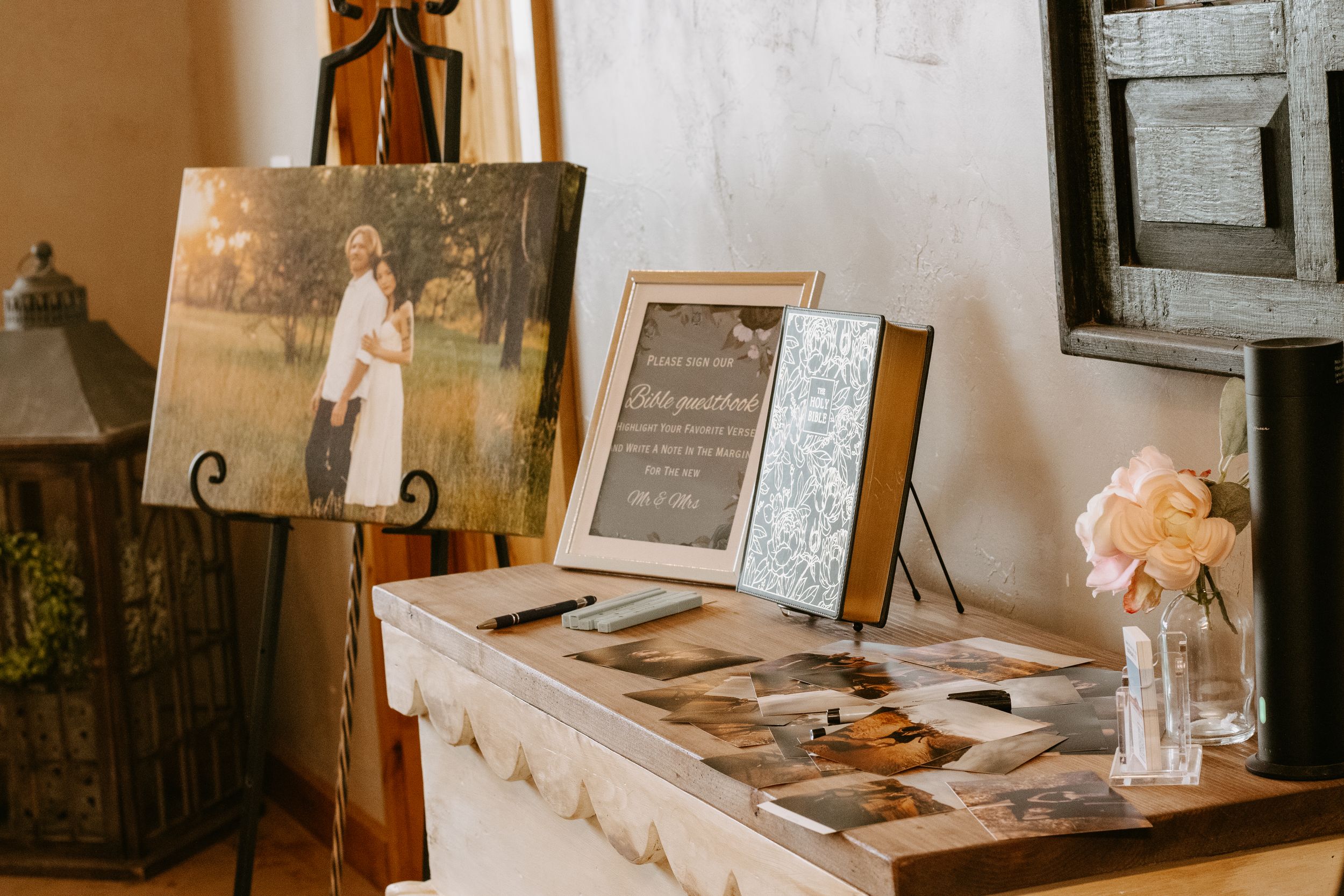 Memorial display table with framed photos, candles, and flowers at a tribute or funeral reception.