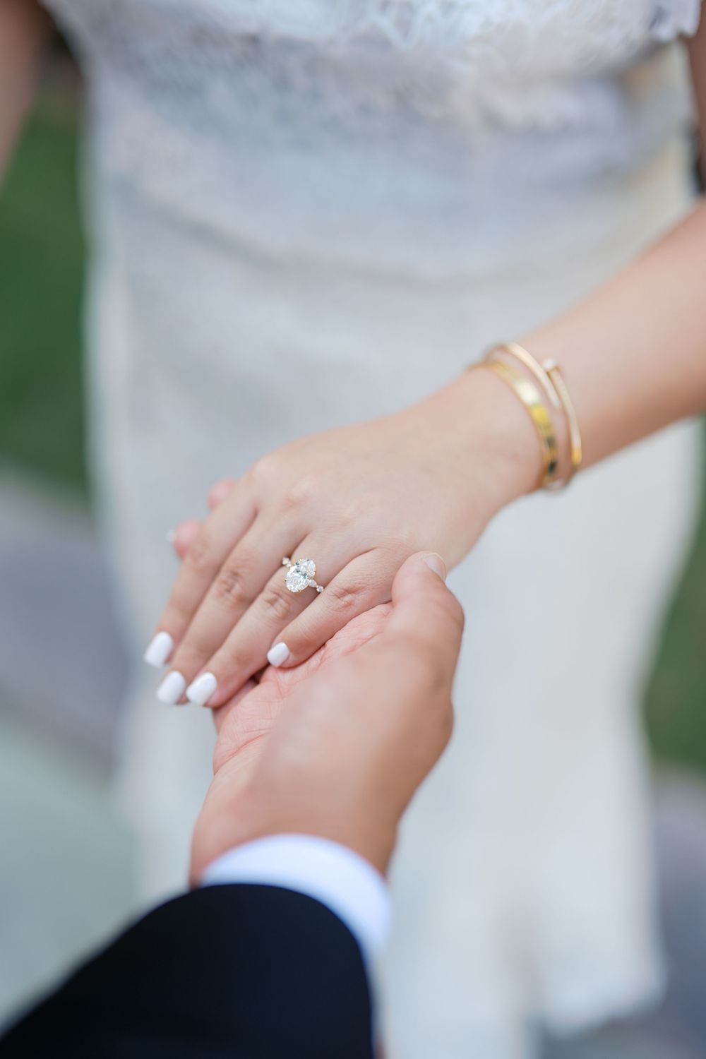 Close-up sequence of hands with wedding rings being held together against a white dress background.