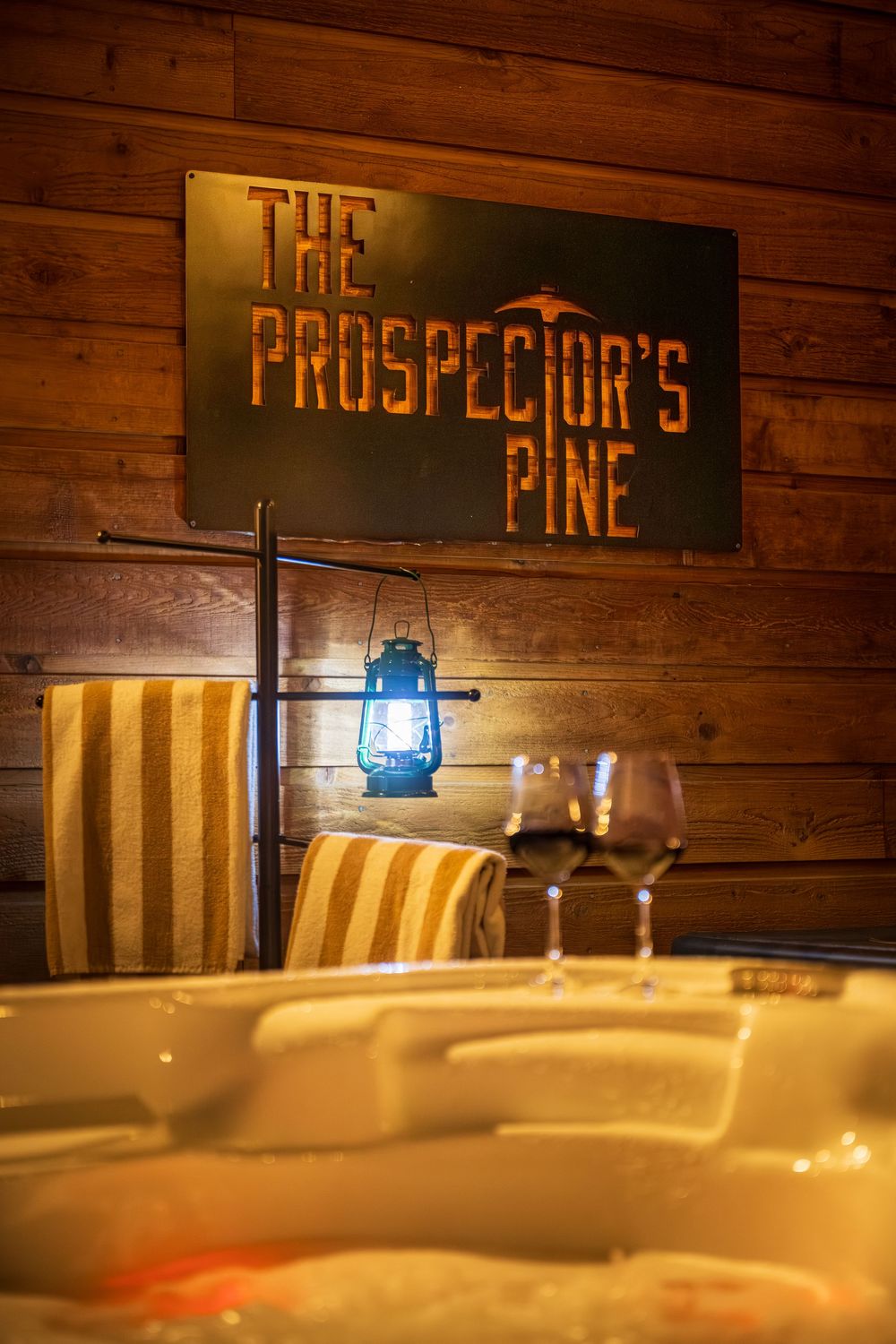 Prospector's Pine sign above wine glasses on the hot tub by Denver Hospitality, Travel & Tourism photographer Captain Colorado Photography.