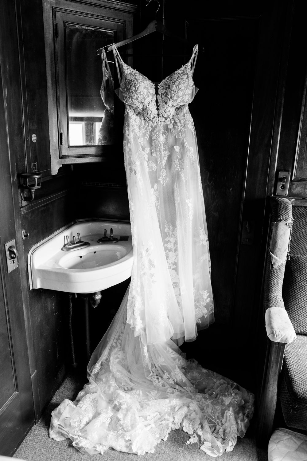 Detail photo of wedding dress hanging up in a train cabin.