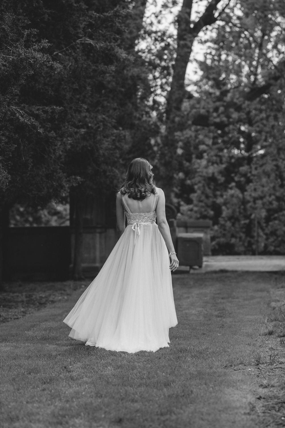 Classic black and white photo of bride walking away from the camera.