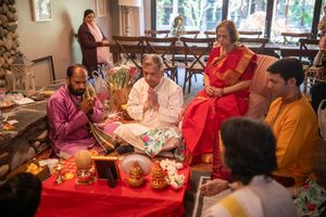 A group of people gather around a table for a festive celebration with food and decorations.