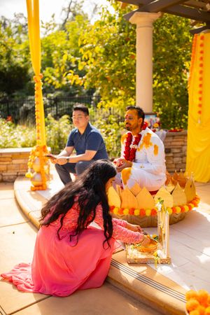 People gather at an outdoor ceremony with yellow decorations and traditional elements on a sunny autumn day.