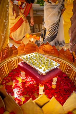 Red rose petals and candles create a romantic display at a religious ceremony or celebration.