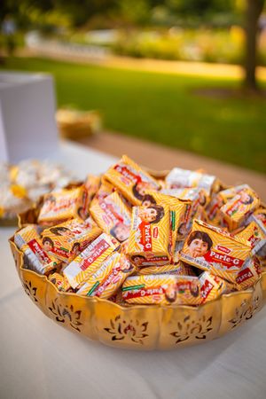 A decorative bowl filled with colorful Twix candy bars arranged for a party or event.
