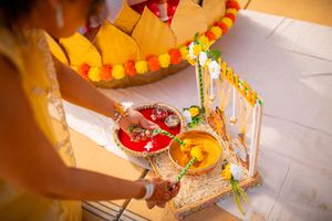 A person's hands carefully assembling colorful Mexican papel picado paper decorations for a festive celebration.