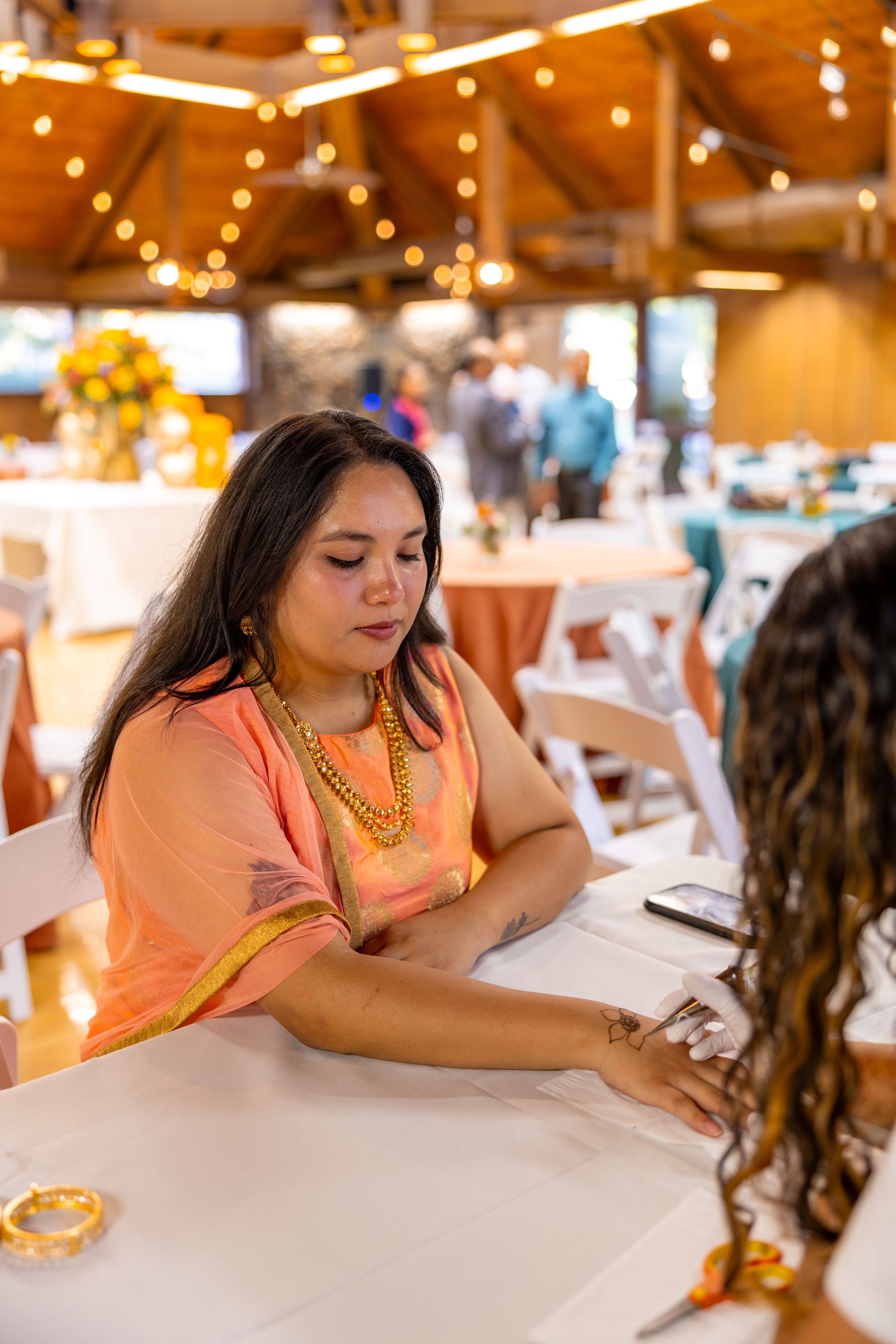 Students study together at a cafe table with books and drinks in a warm, cozy setting.