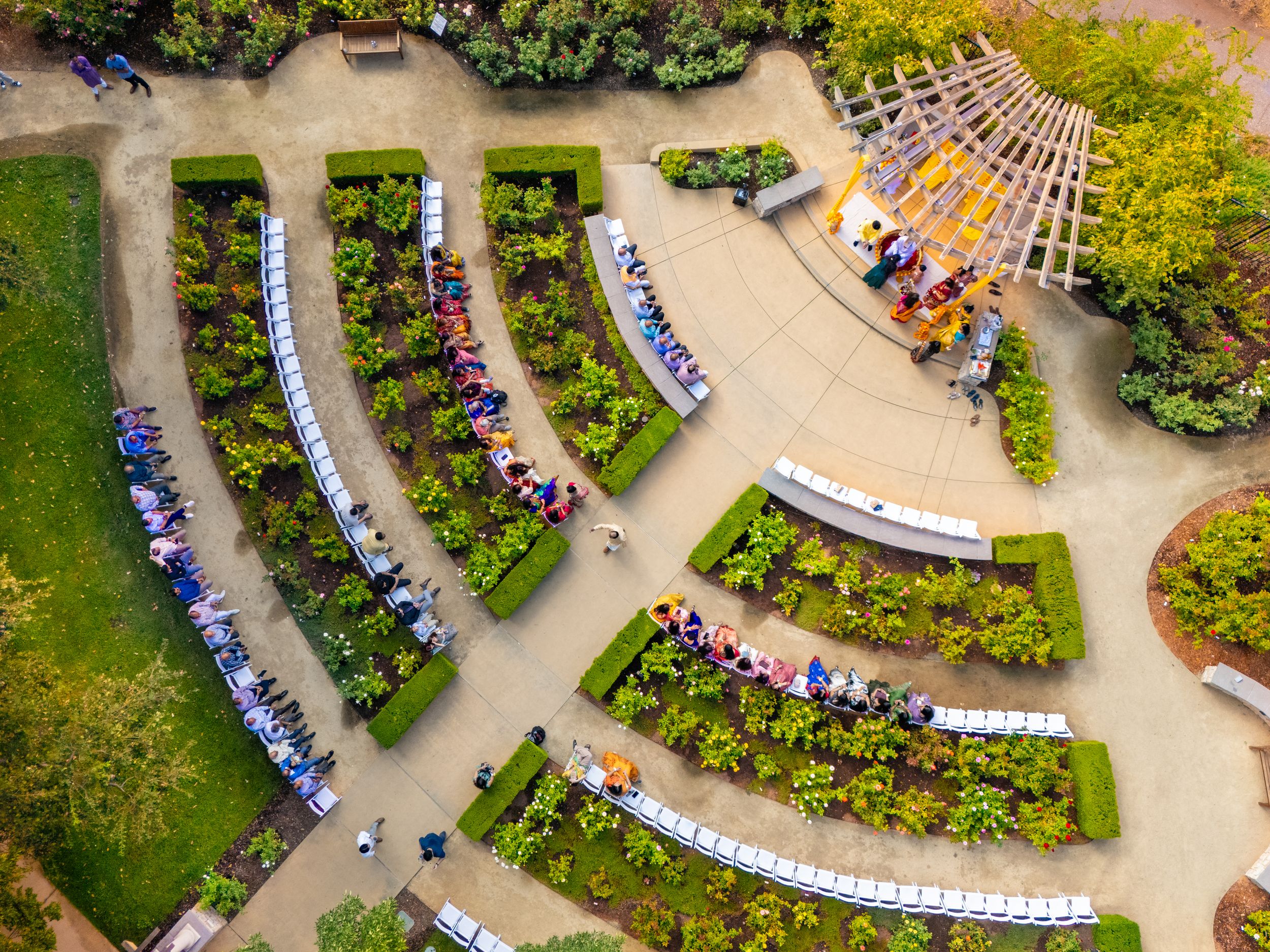 Aerial view of curved garden benches arranged in amphitheater style surrounded by lush greenery and flowers.