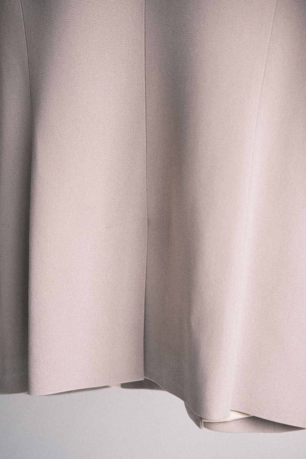 Abstract architectural detail showing a series of soft gray vertical panels with subtle shadows and folds.