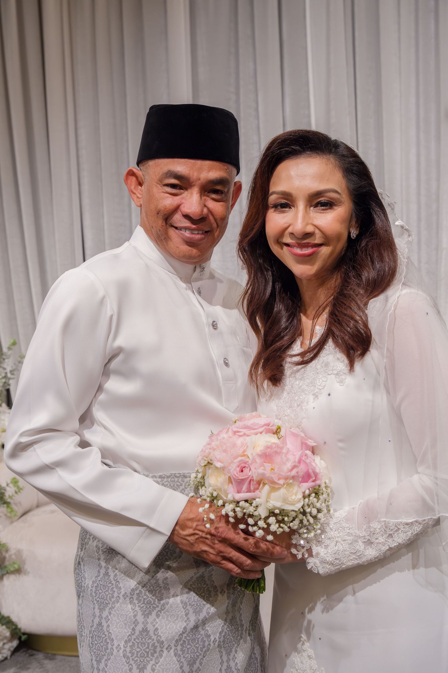 A couple in traditional white attire share joyful moments during their wedding ceremony.