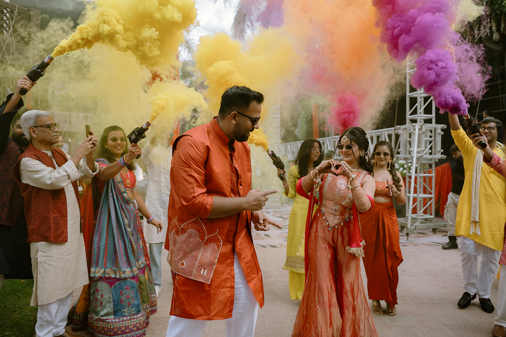 A joyful celebration with colorful powder being thrown in the air during a traditional Holi festival gathering.