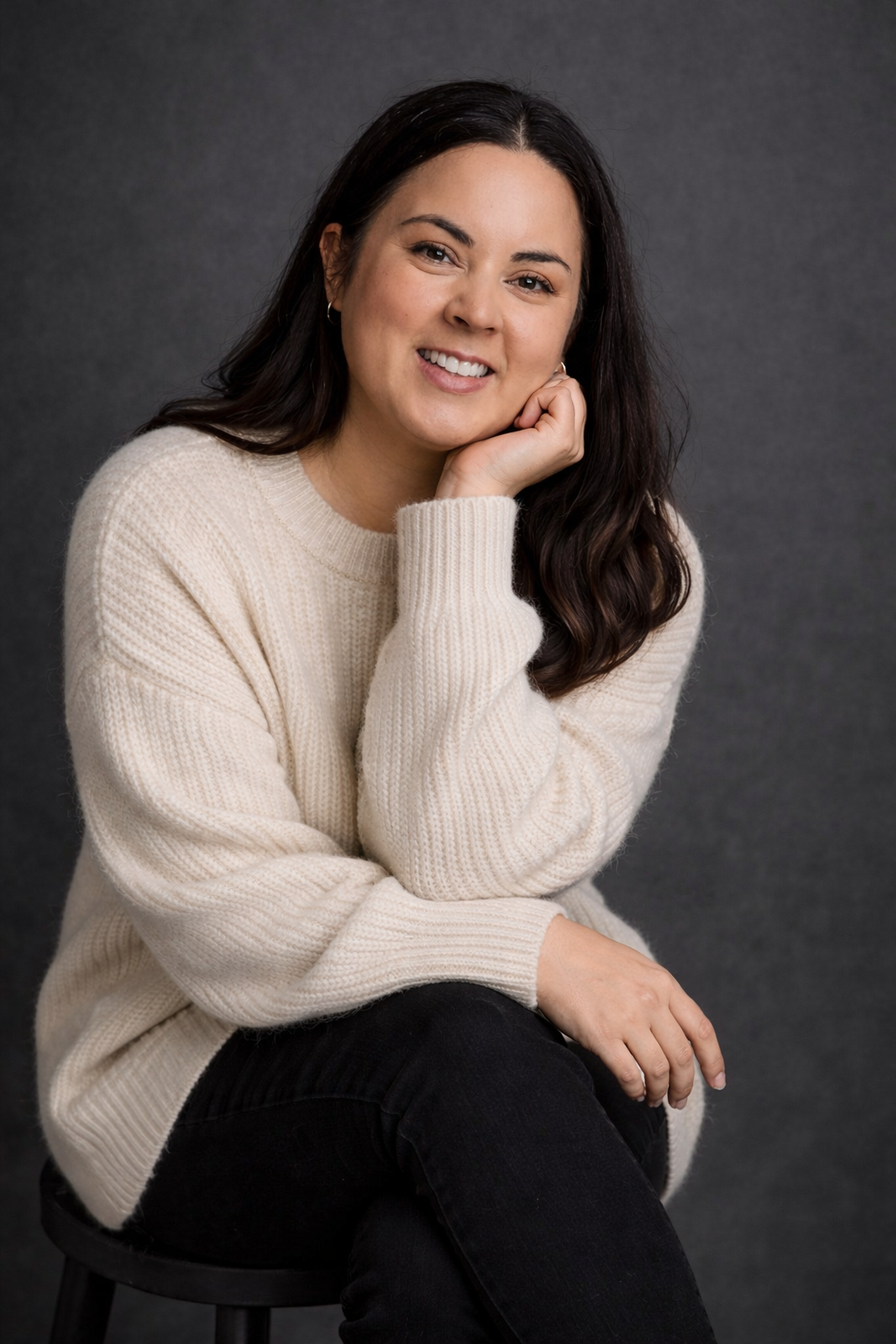 Professional portrait series showing someone in a cozy cream sweater posing against a dark background.