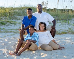 A group enjoys a relaxing day sitting together on a sandy beach near the ocean.