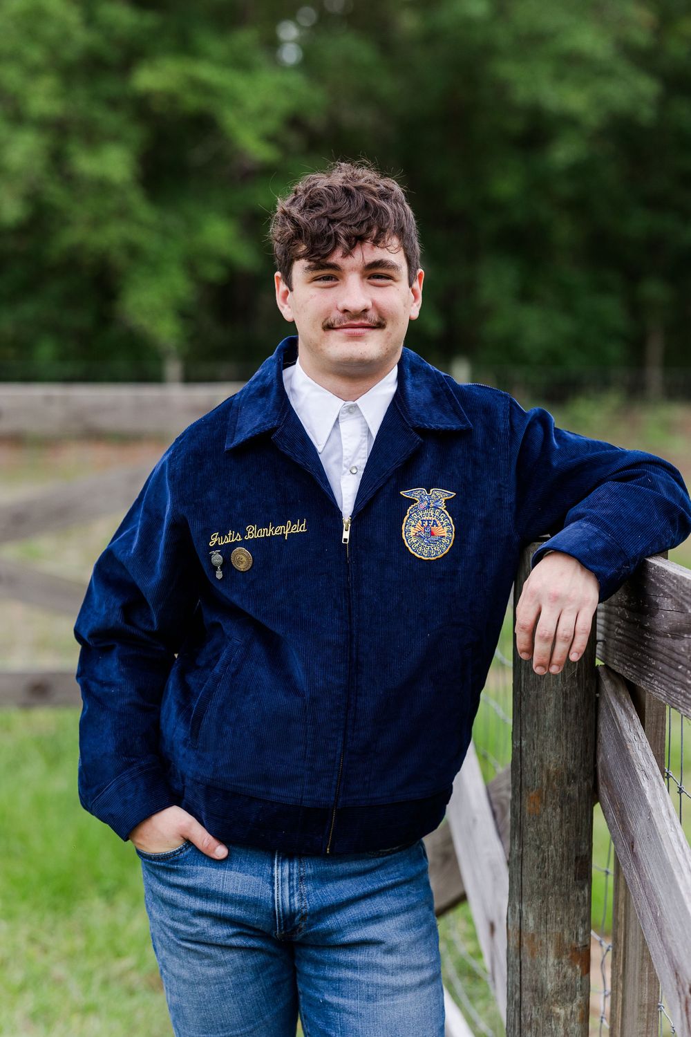 A series of casual poses showing a navy FFA jacket and jeans against a wooden fence.