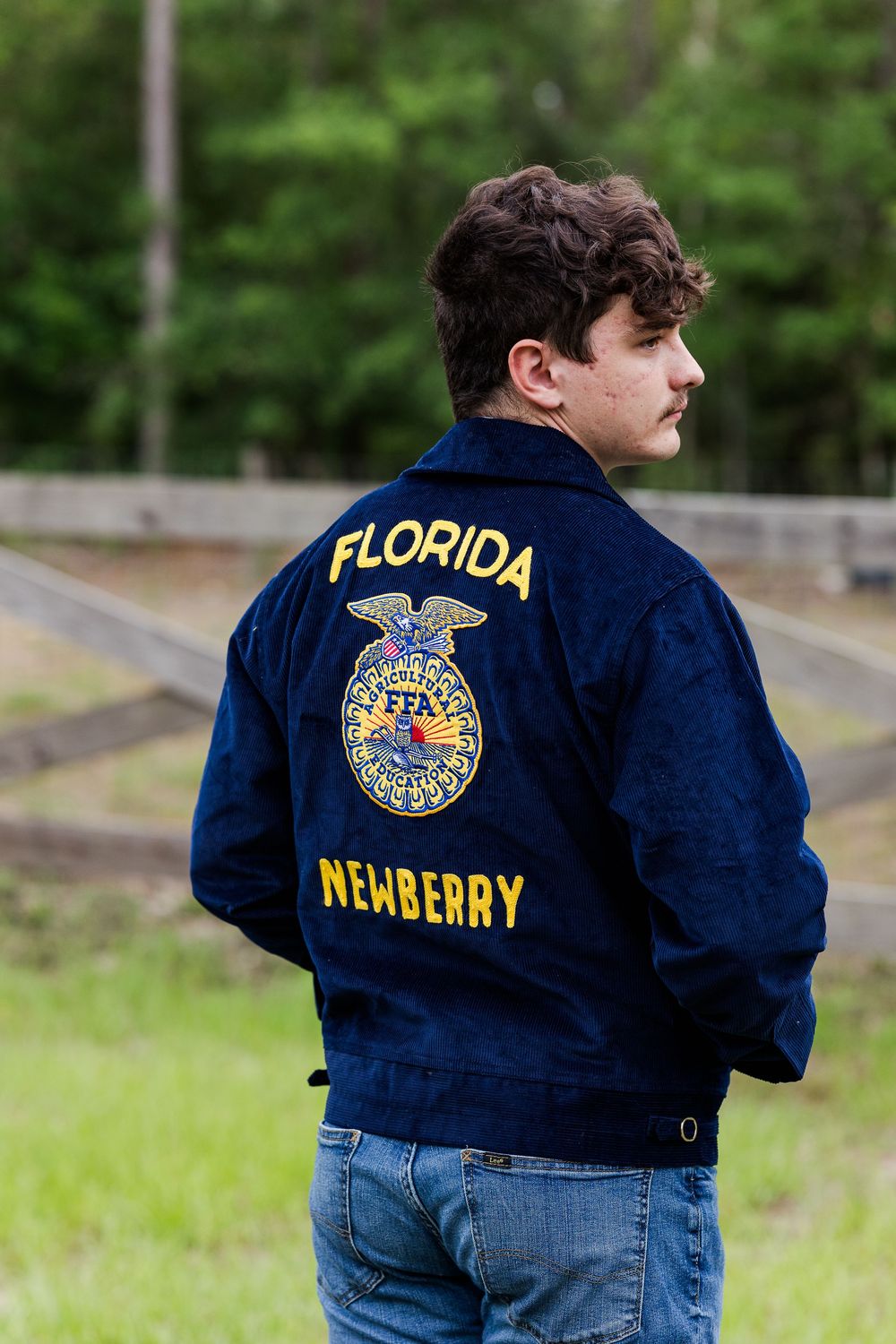 Navy blue FFA jacket with embroidered Florida Newberry chapter logo displayed from different angles.