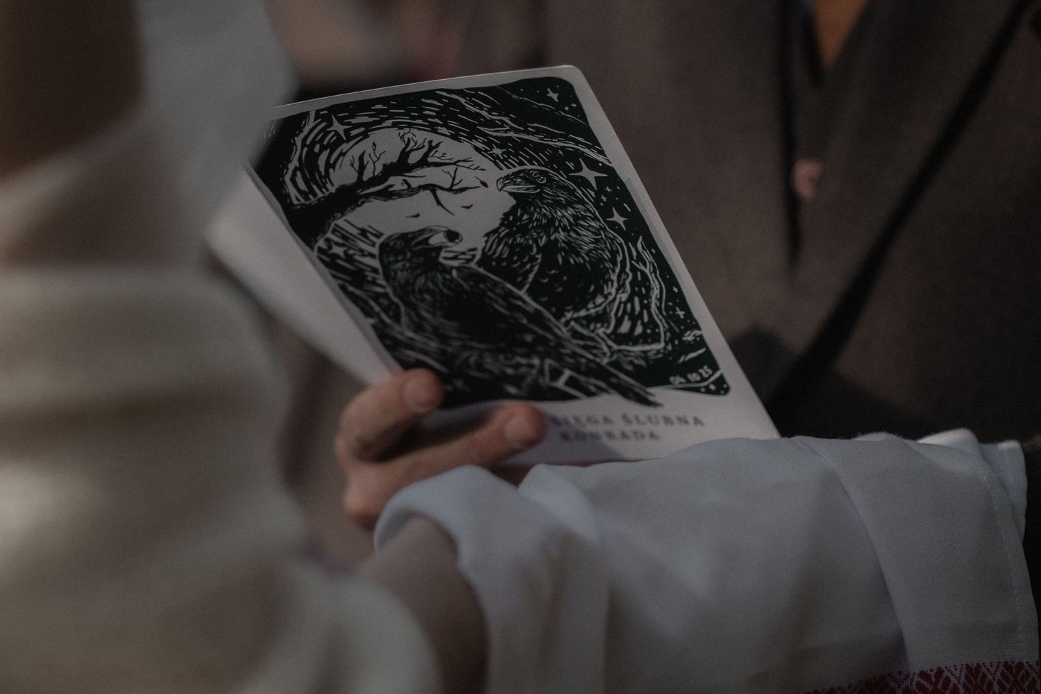 Close-up view of hands writing in a notebook with a pen while working at a desk.