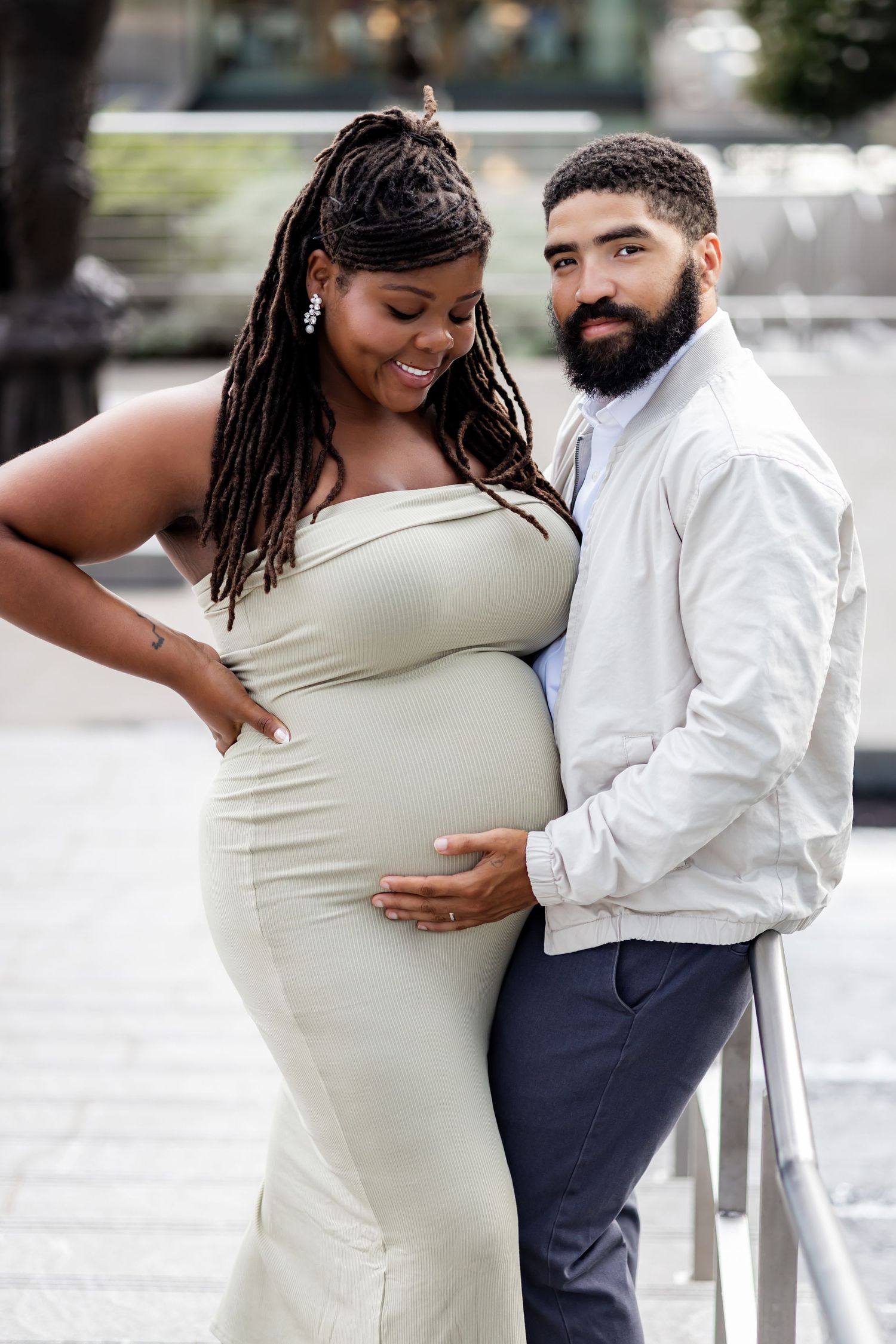A loving couple embraces during a maternity photo shoot, with the expectant mother wearing an elegant dress. RVA Maternity photographer