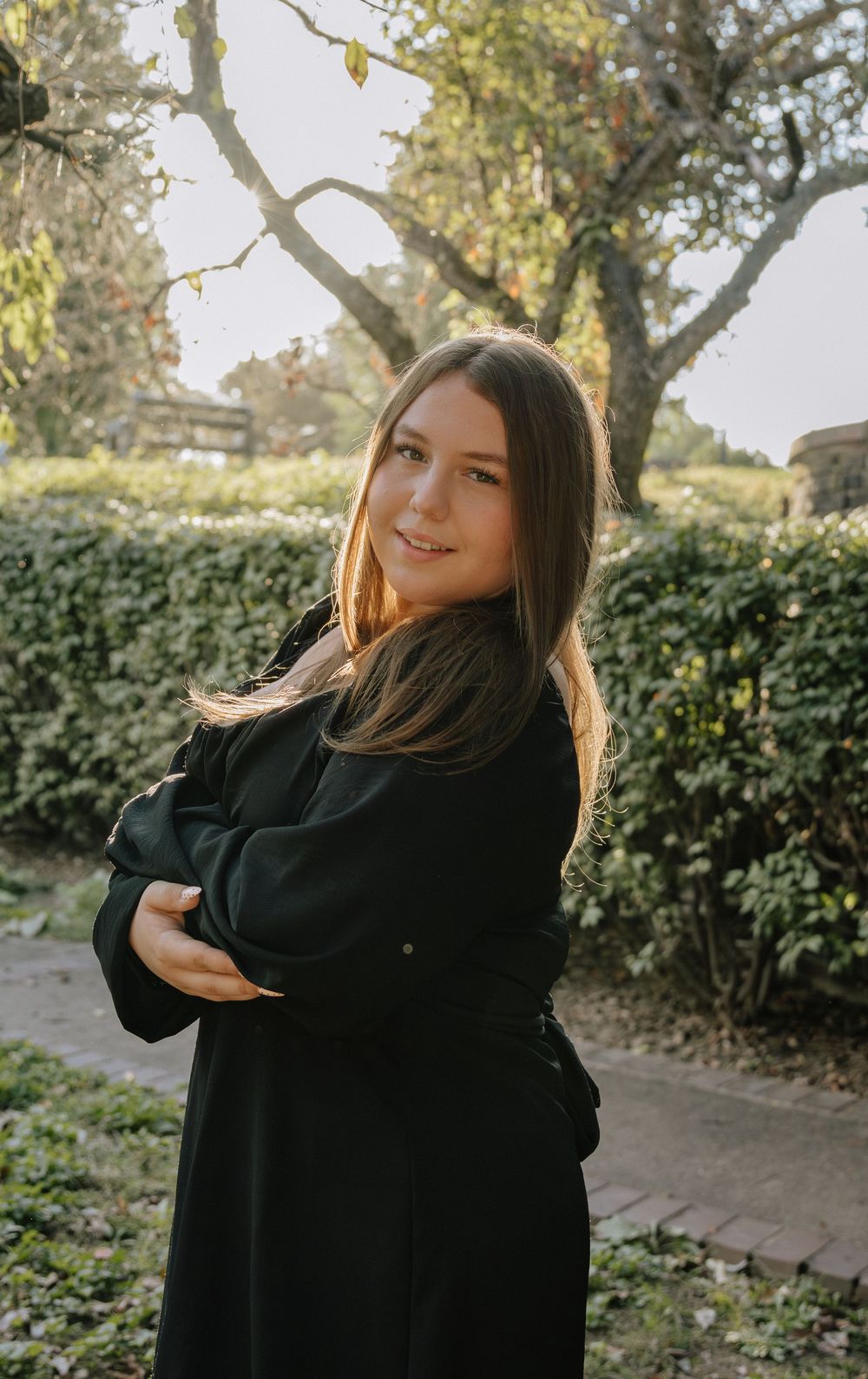 Natural light portrait session in a garden setting with someone wearing all black.