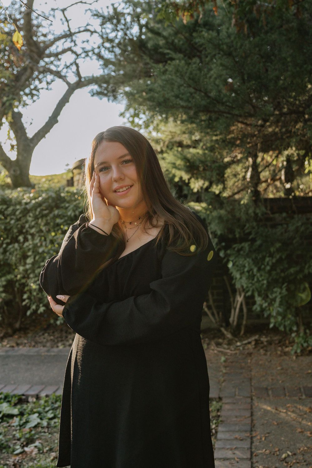 Casual outdoor photography session featuring natural poses against a leafy garden background.