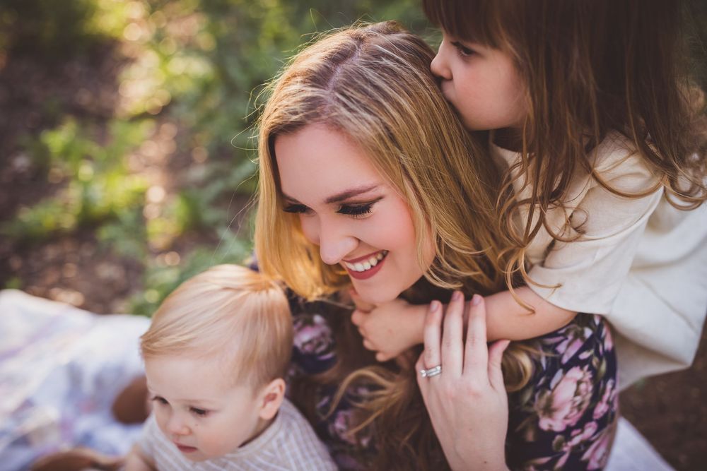 Mother and child share tender moments outdoors in a series of intimate portraits against natural greenery.