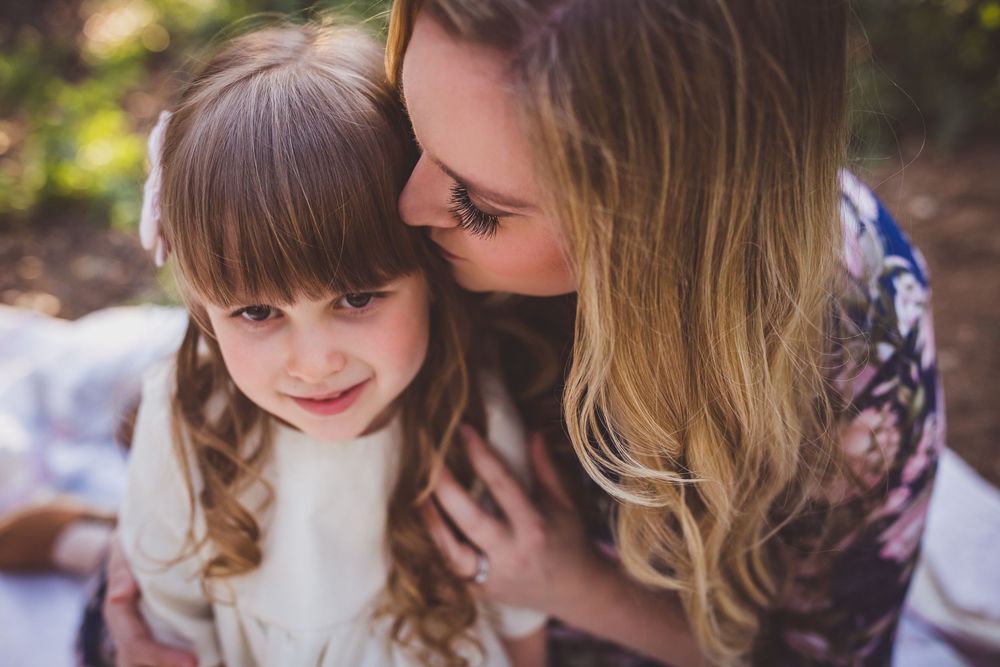 Sweet bonding moments between mother and child photographed in natural outdoor lighting.