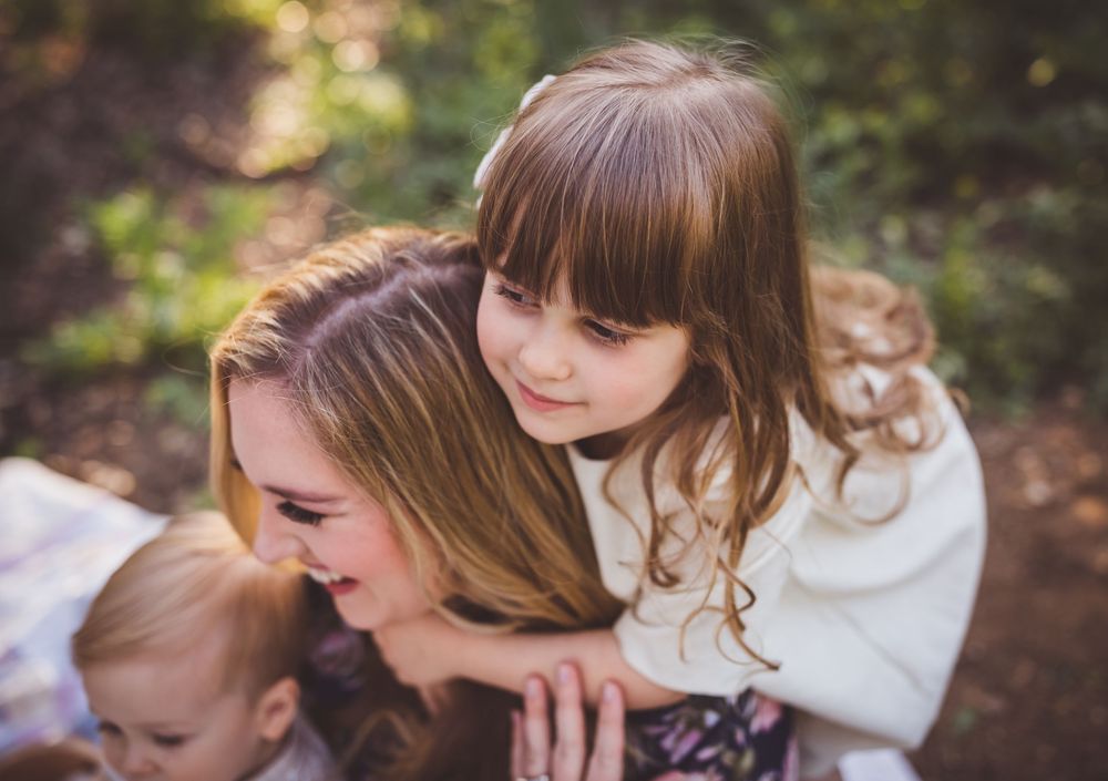 A collection of intimate family portrait photographs arranged in a horizontal strip showing tender moments outdoors.