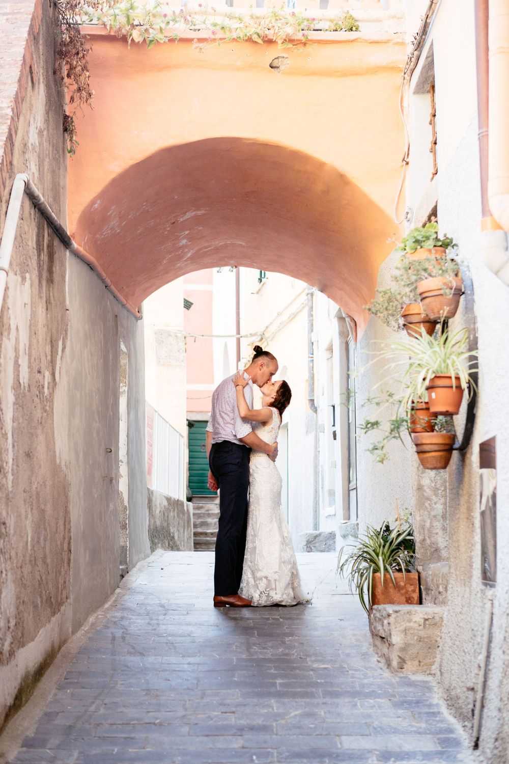 A romantic couple embraces in an arched alleyway in Riomaggiore during their Cinque Terre elopement.