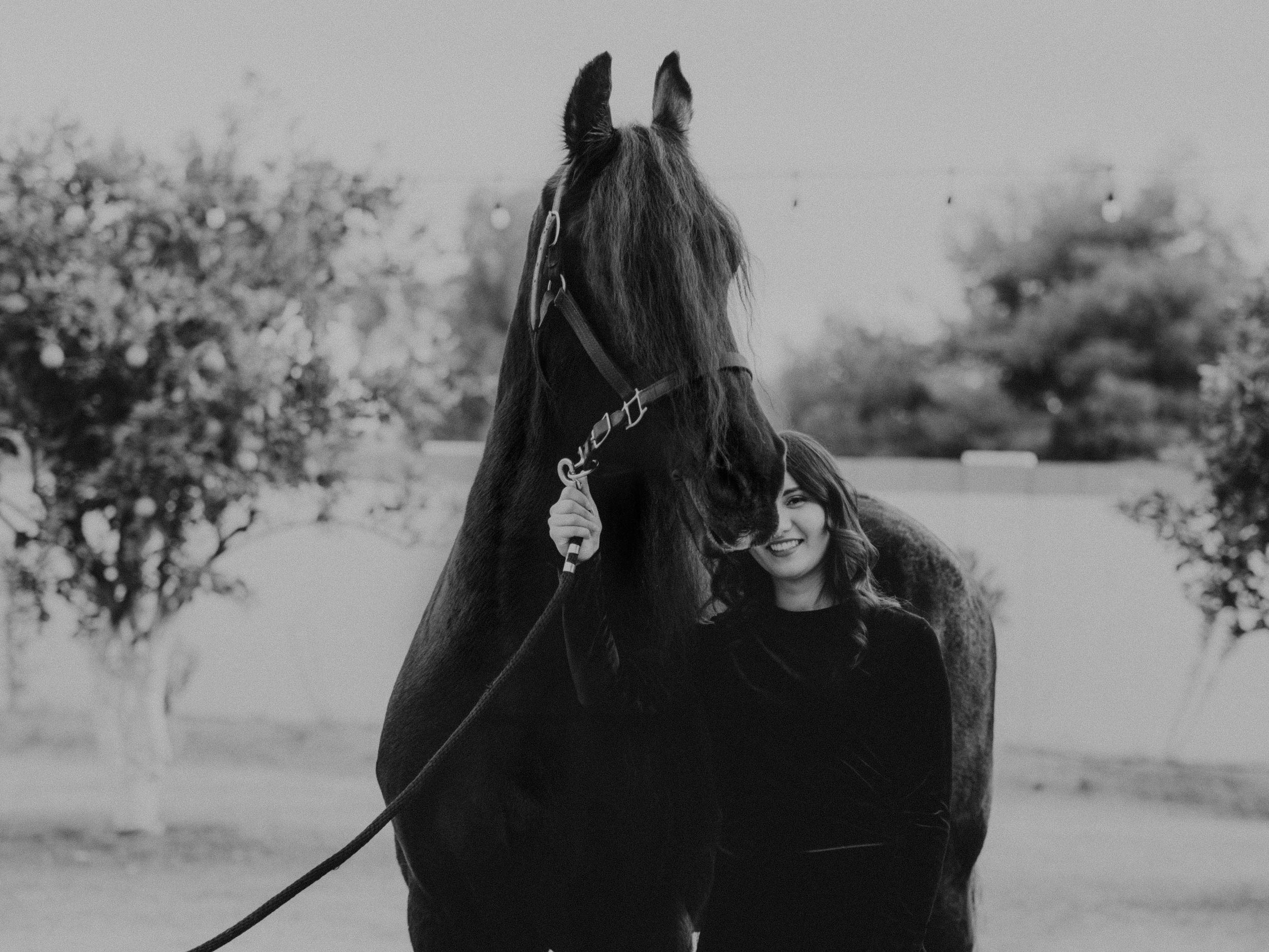 A dramatic black and white portrait of a horse and rider in profile.