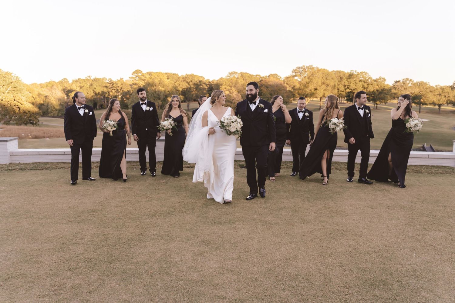 Wedding party walking with the bride and groom at Meyers Park Country Club in Charlotte, NC