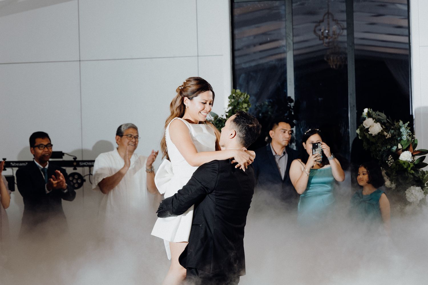 Couple dancing amid fog on the dance floor captured by Apertured Media Auckland Wedding Photographer.