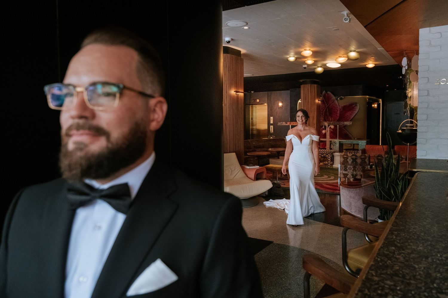 Wedding day scene in hotel lobby with formal attire and decorative lighting.