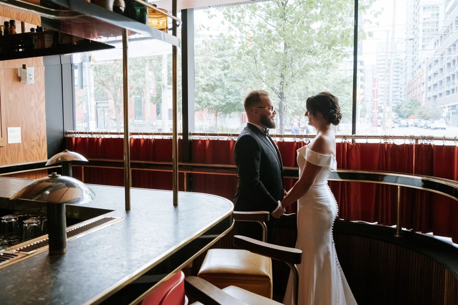 Couple shares intimate conversation in modern restaurant with red booth seating.
