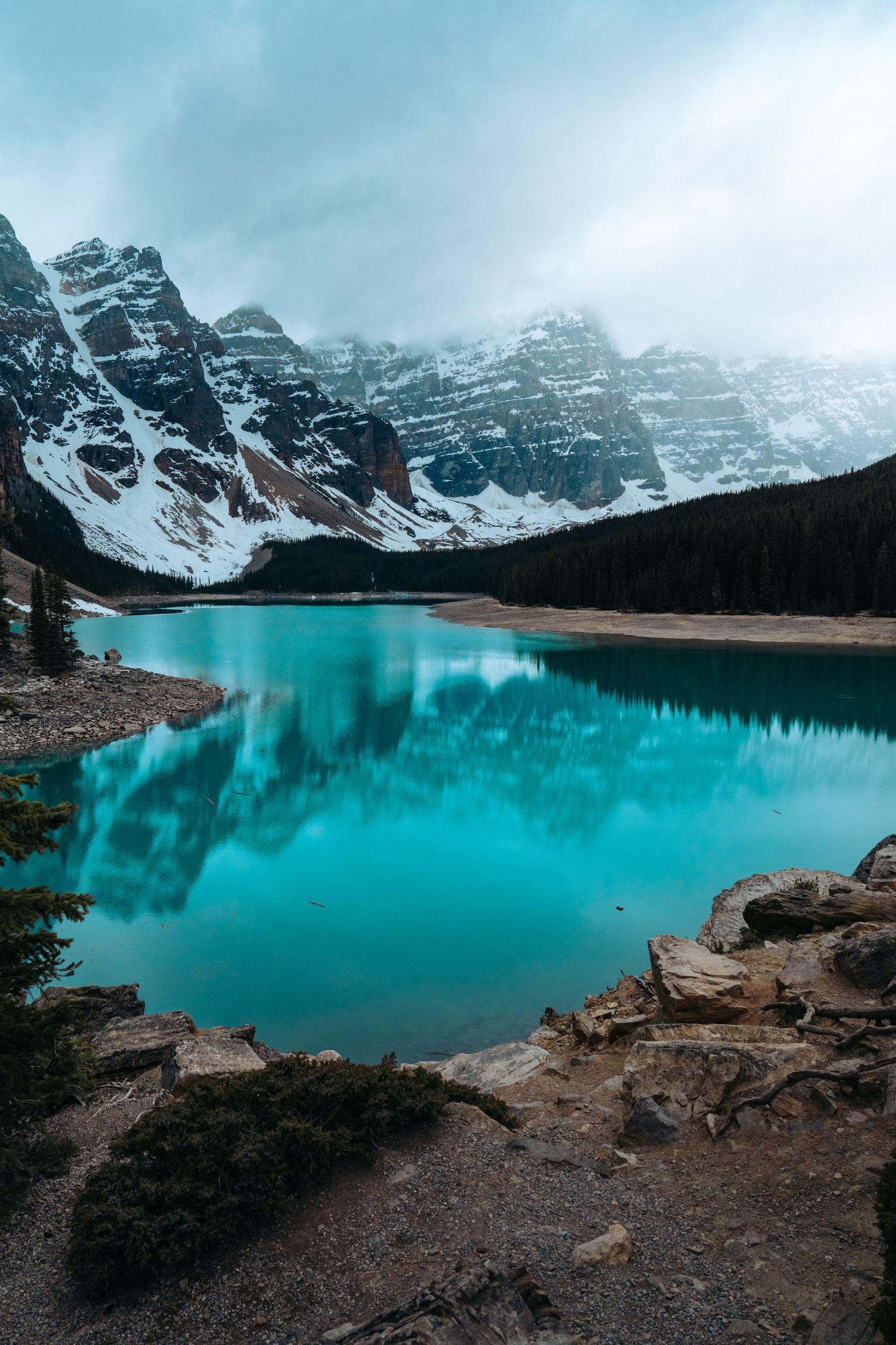 Turquoise waters of Moraine Lake reflect snow-capped mountain peaks in Banff National Park.