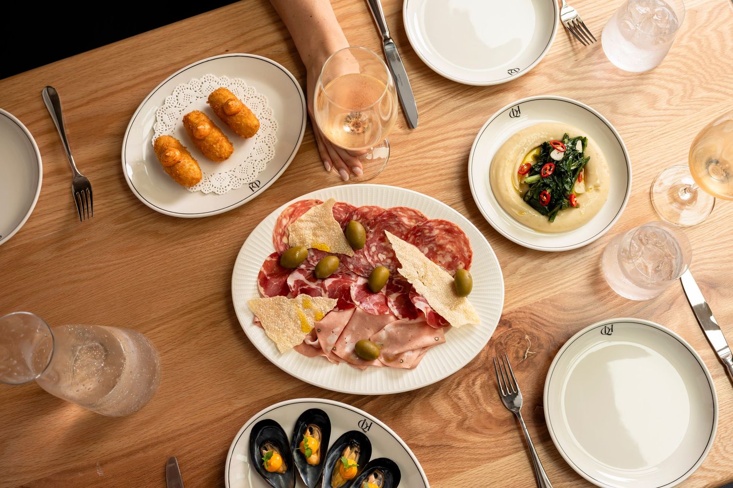 Overhead food photography showcasing shared Italian dining experience and contemporary restaurant styling