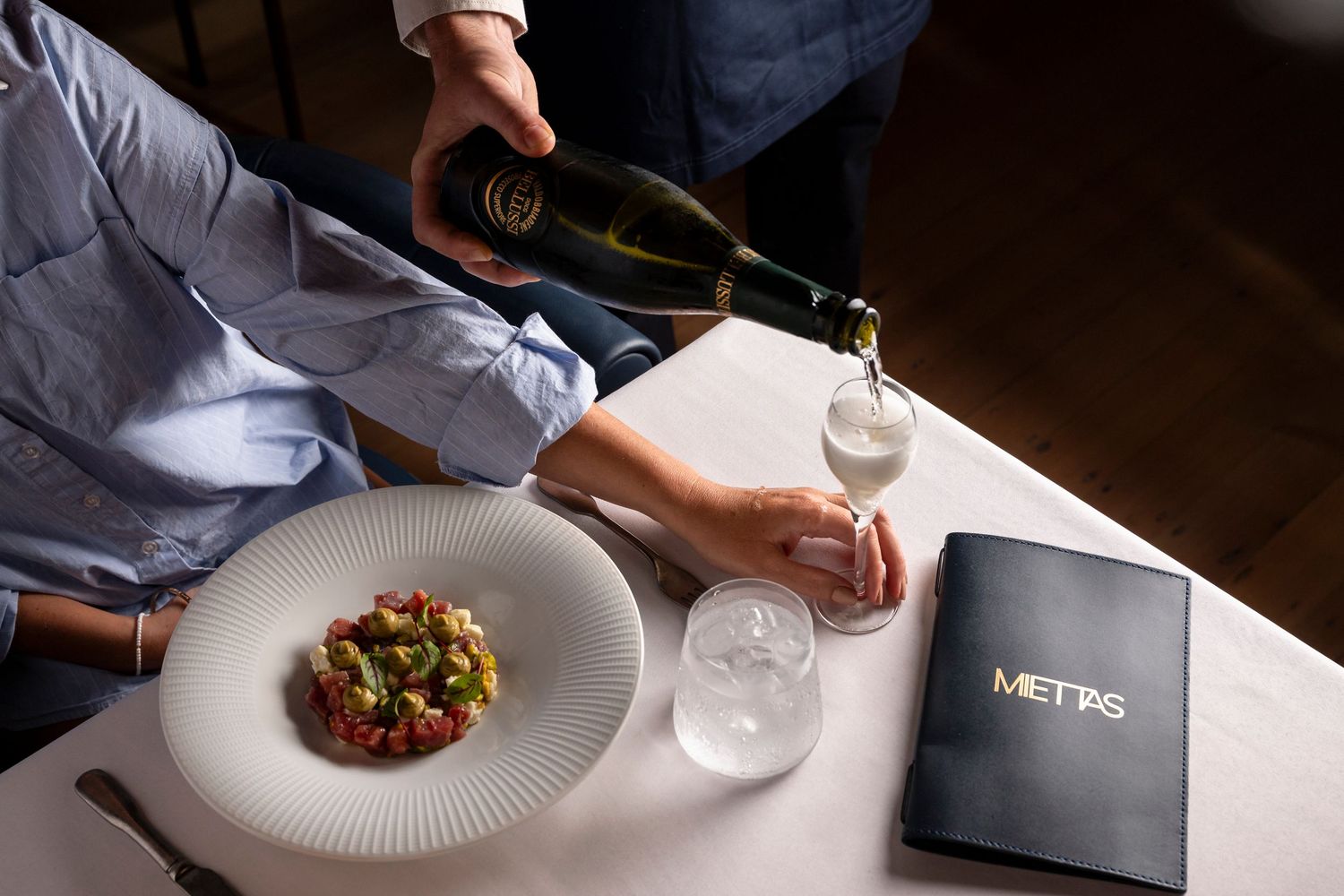 Fine dining photography capturing champagne service and contemporary restaurant dining experience
