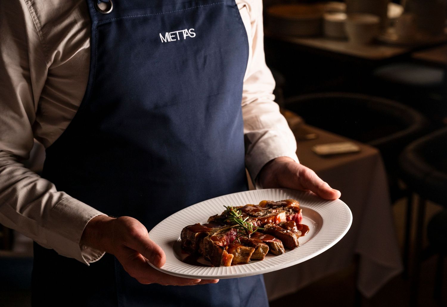 Chef and hospitality photography featuring plated steak dish in contemporary fine dining restaurant