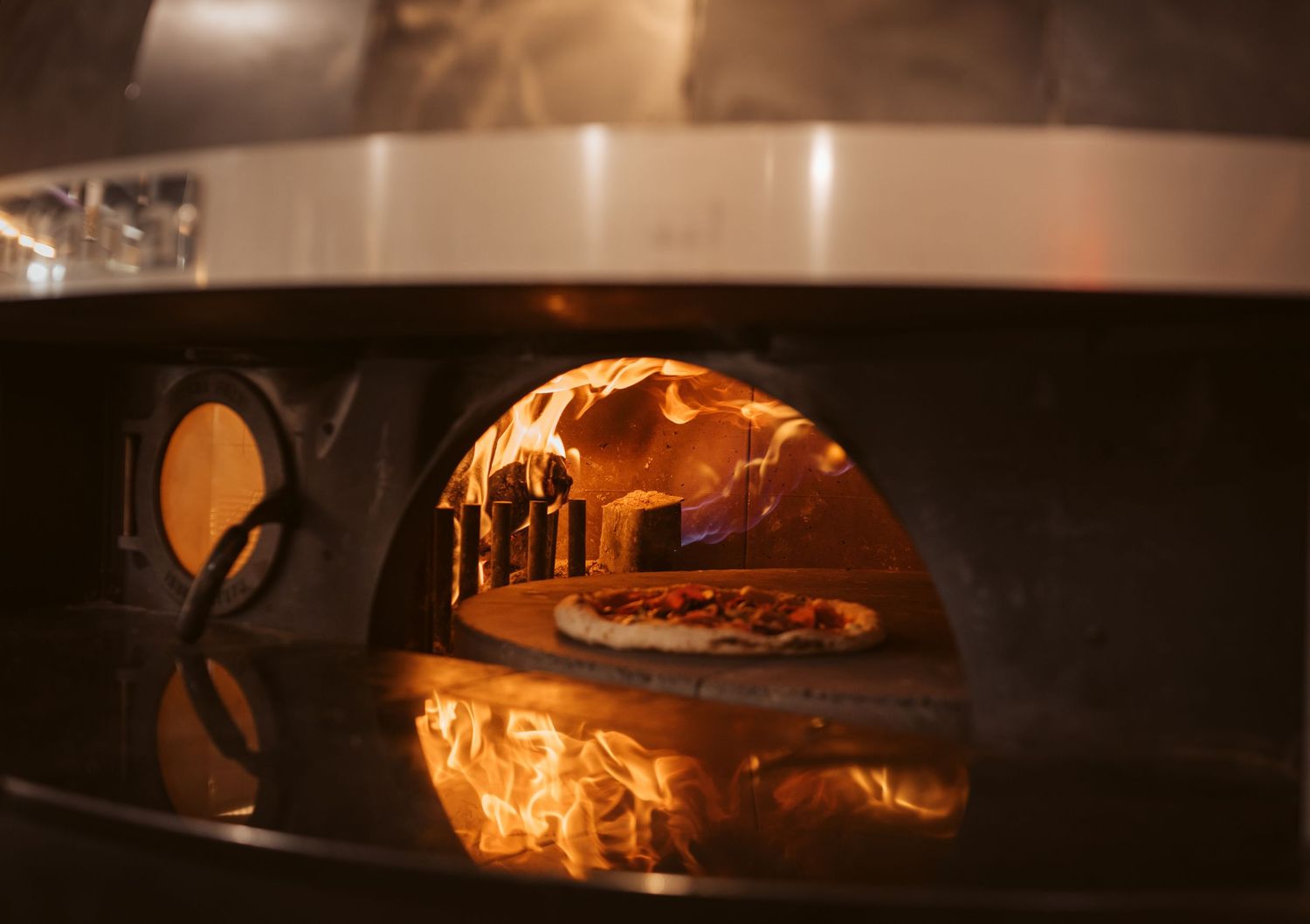 Woodfired pizza photography showcasing flames and artisan cooking in commercial hospitality kitchen