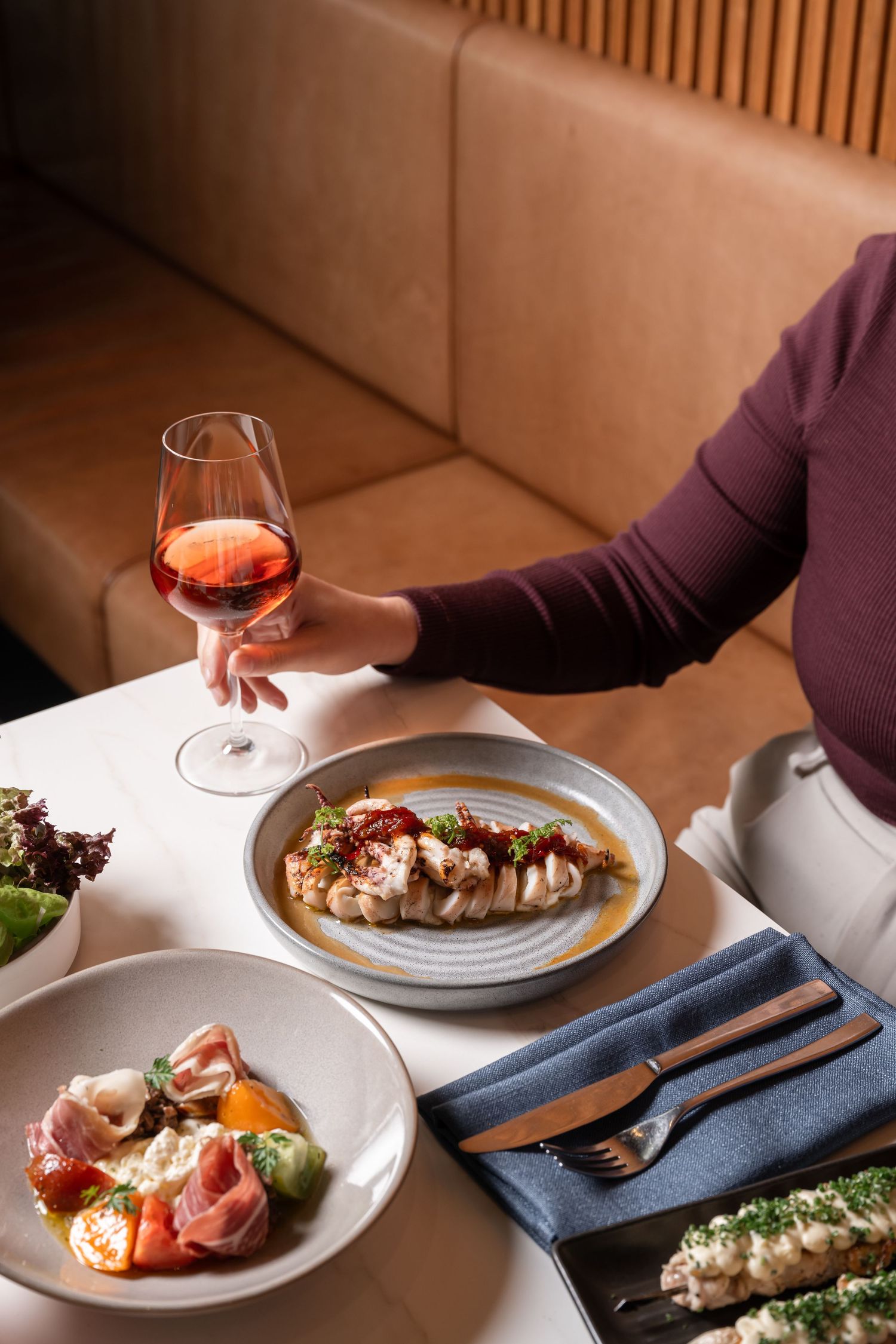 Restaurant food photography showcasing shared dining experience and warm contemporary hospitality styling